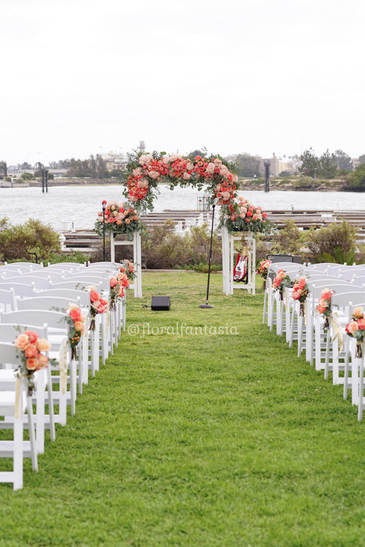 Wedding arch arrangement and aisle florals grace the wedding chairs and arch for the ceremony. We deliver flowers all over San Diego County. 